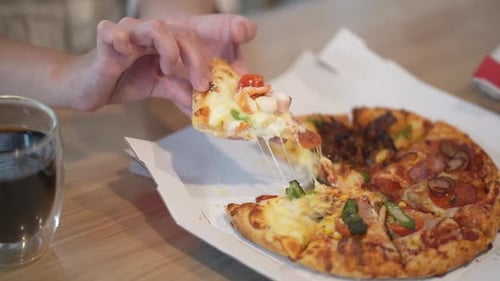 Hand Picking Up Slice of Delicious Pizza