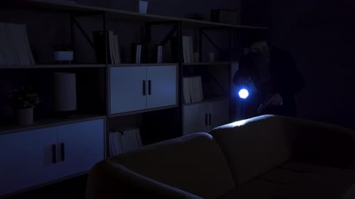 Man with Gun Searching a Dark House at Night