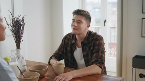 Young Adult Man Talking with Friend at Breakfast