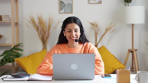 Woman with Headset Working on Laptop at Home