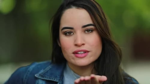 Attractive Woman Blowing Kiss to the Camera Outside