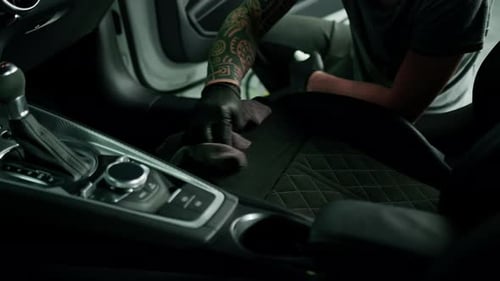 Gloved Detailer Cleaning Car Interior Meticulously