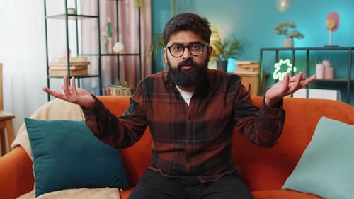 Bearded Man Gesturing While Sitting on Couch