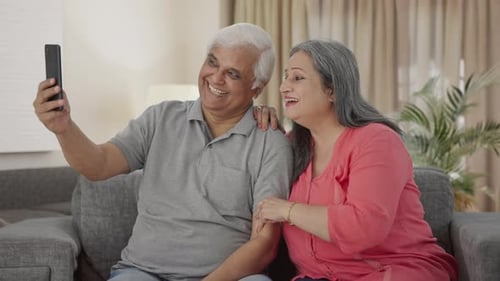 Happy Indian old couple clicking selfies