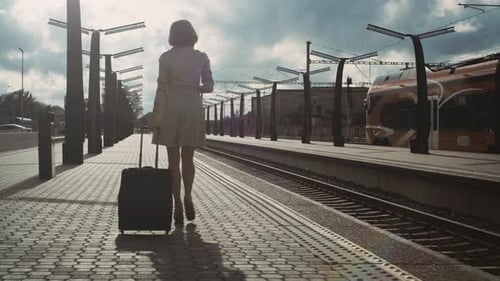 Following Shot of Confident Woman with Luggage Walking through Railway Station