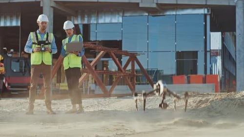 Two Specialists Controlling Drone on a Construction Site. Architectural Engineer and Safety Enginee