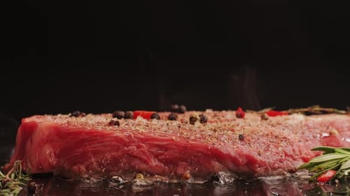 Fresh Marbled Beef with Pepper Salt and Rosemary Closeup Macro Cooking Juicy Steak on Grill with Oil