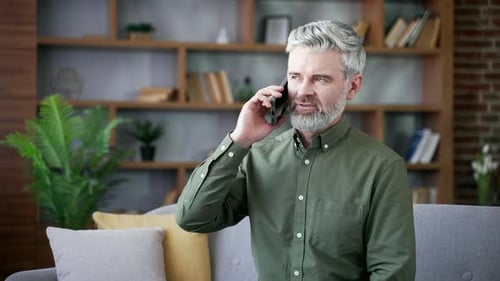 Man Talking on Phone Sitting on Couch