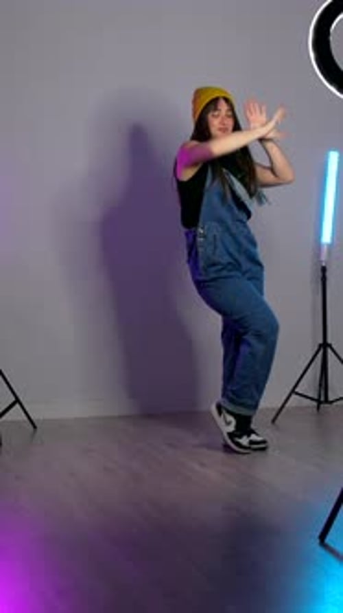 Young dancer performing choreography in studio with neon lights