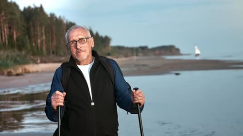 Sports Aging 70s Man Posing with Scandinavian Walking Stick at Sea Beach Sunset Landscape