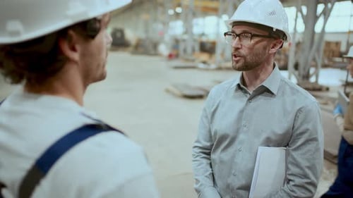 Factory Engineer Greeting Worker with Handshake and Talking to Him