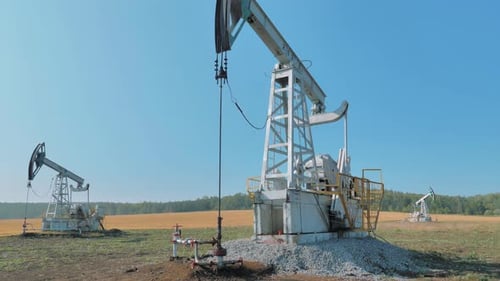 Pumping Rigs Extracting Oil From an Oil Well in Vast Oil Field Oil Industry Equipment