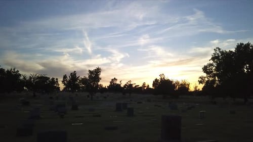 Spooky and haunted view of Cemetery during golden hour. Silhouette. Drone flying low.