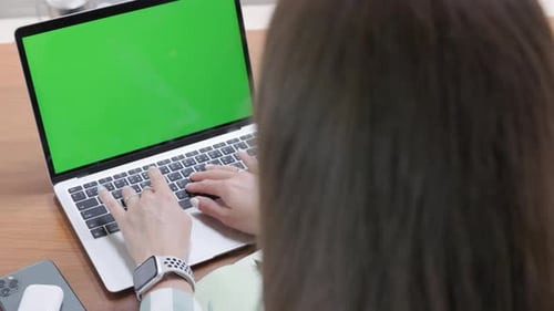 Closeup Side View of a Businesswoman Typing on a Laptop Keyboard at Her Home Office Desk Using