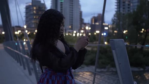 Beautiful Young Woman Using Smart Phone on Urban Bridge at Night Adult