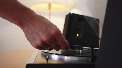 Hand Placing Needle on Record Player to Play Music