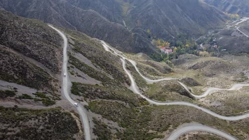 Vehicles climb dirt road to mountain pass in Villavicencio, Argentina