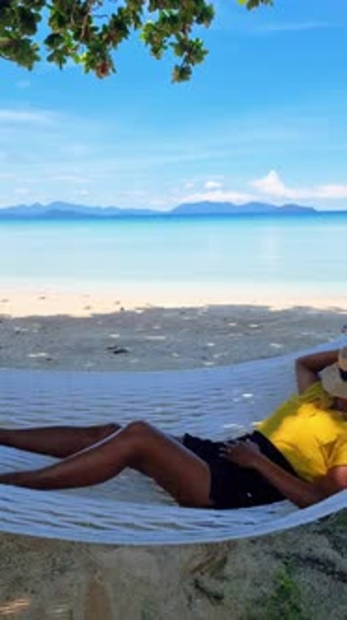 a Woman is Laying in a Hammock on the Beach Koh Kood Thailand