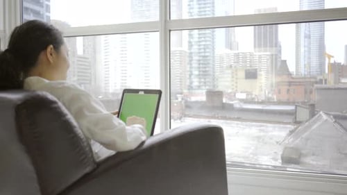 Woman Using Green Screen Tablet in City Apartment