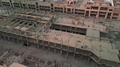 Zumbido aéreo de las ruinas abandonadas de un megaproyecto de concreto con barras de refuerzo expuestas y patio vacío