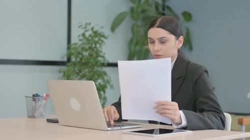 Young Adult Woman Works in Office With Laptop