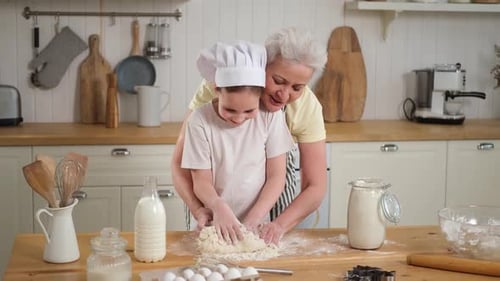 Grandmother and Child Kneading Dough Together in Kitchen