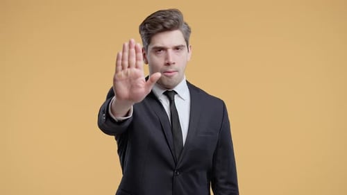 Serious Man in Suit with Stop Gesture