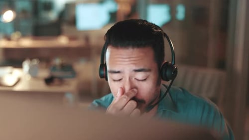Night, businessman and burnout with headache, stress or overworked with call center deadline