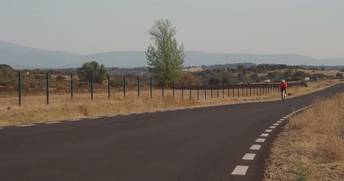 Road Biker Man Sprinting on a Road While Training