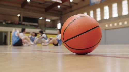 Basketball Stands Still As Female Players Rest on Court