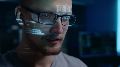 Portrait of Software Developer / Hacker wearing Glasses Working on Computer, Projected Code Numbers