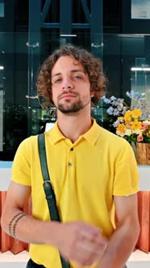 Man in yellow shirt standing in an office building. Vertical