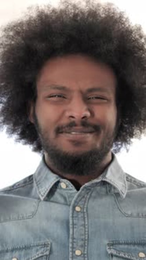 Man with Afro Hair and Denim Shirt Faces Camera