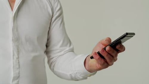 Left Hand Scrolling Quickly Smartphone Business Man in White Shirt Browsing Social Media Isolated on