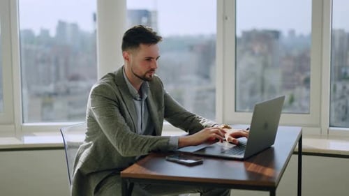 Young Businessman Working in an Office Space Focused Young Man Typing on a laptopSteadycam Shot
