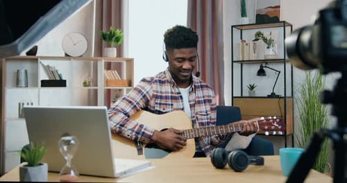 Smiling Man Plays Guitar and Records Video