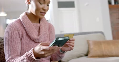Woman Uses Phone and Credit Card at Home