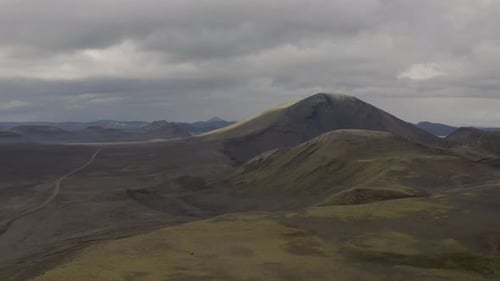 Aerial revealing shot of crater lake inside erupted volcano during cloudy day - Iceland,Europe