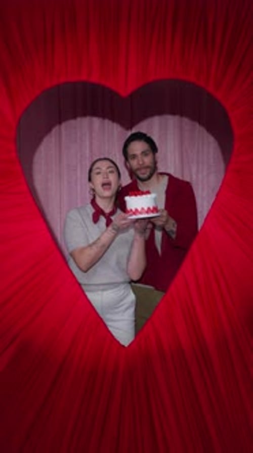 Latin Couple Hugging Behind Heart Shaped Frame in Valentine Booth