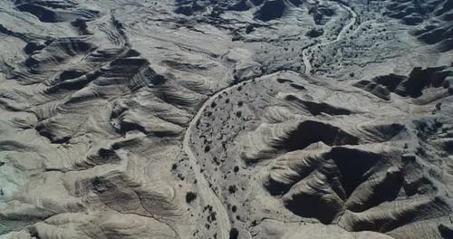 Cinematic Aerial View of Rugged Desert Ridges and Winding Canyons