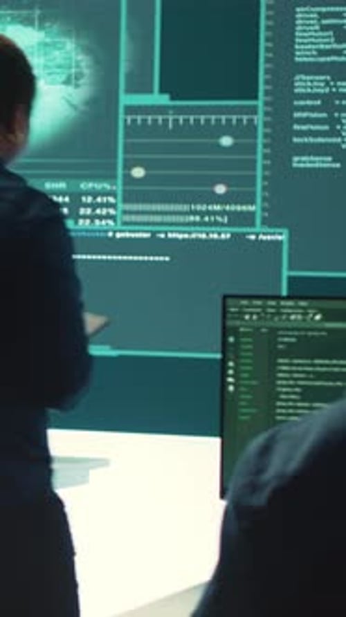 Two Professionals Working with Code in Modern Office