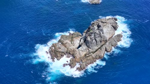 Waves are splashing into the rocks.