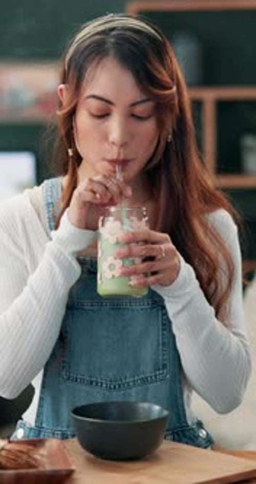 Young Woman Drinking a Beverage with a Straw