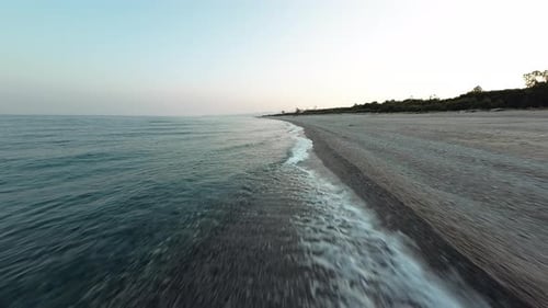 Flying Over Calm Ocean Beach