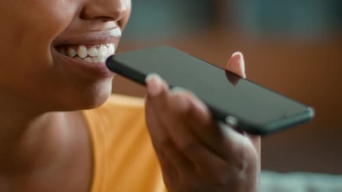 Woman Speaks Into Mobile Phone Microphone in Close-up