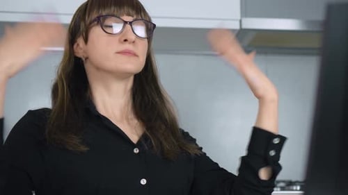 Woman Feels Hot and Short of Air Waves Her Hands at Herself While Working in Home Office Due to