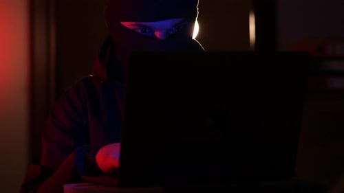 Masked Man Typing on Computer