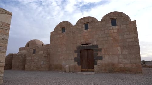 Wide Pan Shot of UNESCO World Heritage Site Qasr Amra Desert Castle with Three Domes on a Cloudy Day