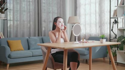 Woman Applying Facial Mask at Vanity Table