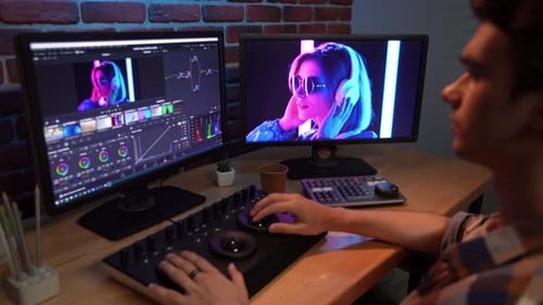 Man Video Editing at Desk in Urban Office
